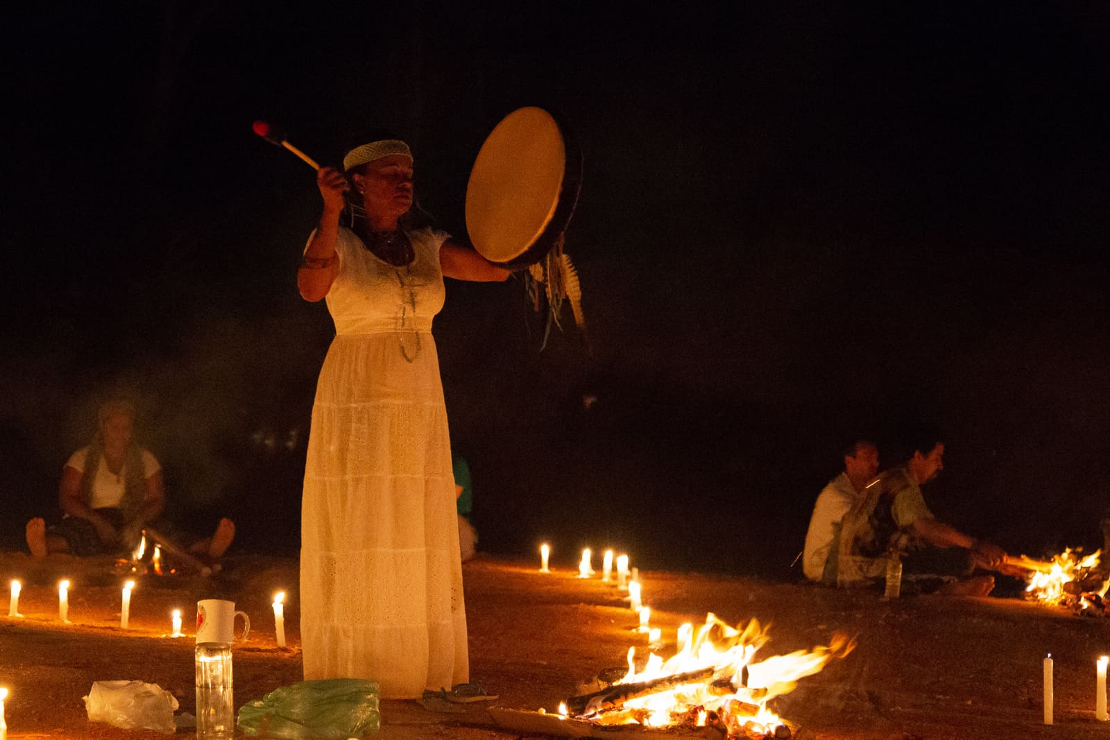 Xamã Ayala tocando o tambor xamânico durante uma cerimônia noturna